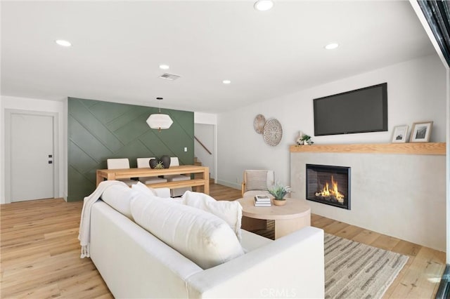 742 Hudson Ave, Costa Mesa, CA 92626 - living area featuring a lit fireplace, light wood-style floors, stairway, recessed lighting, and an accent wall
