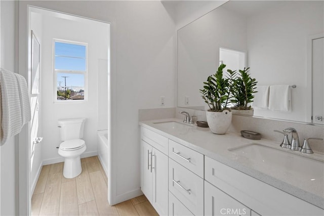 415 E 220th St, Carson, CA 90745 - bathroom featuring double vanity, toilet, baseboards, and wood finished floors