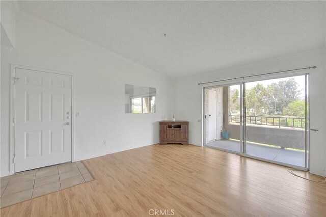 1995 Las Colinas Cir Unit 307, Corona, CA 92879 - unfurnished living room featuring lofted ceiling, wood finished floors, and healthy amount of natural light