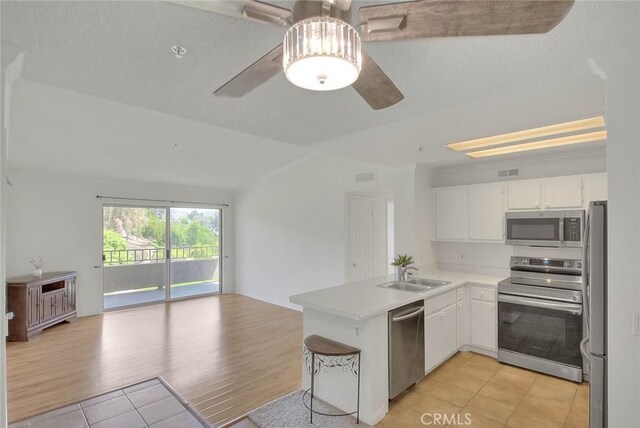 1995 Las Colinas Cir Unit 307, Corona, CA 92879 - kitchen featuring stainless steel appliances, a sink, open floor plan, ceiling fan, and light tile patterned floors