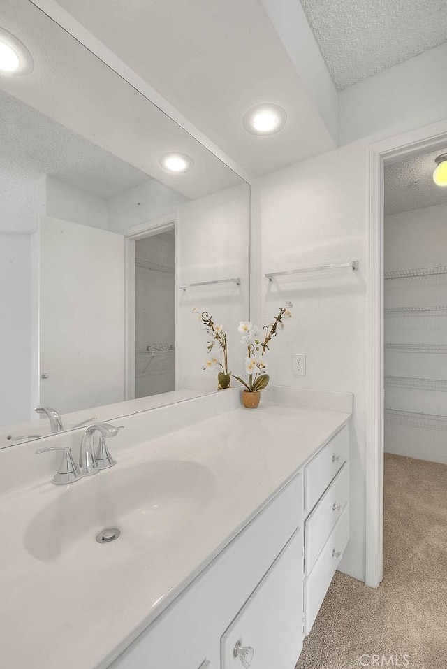 1995 Las Colinas Cir Unit 307, Corona, CA 92879 - bathroom with vanity, recessed lighting, a spacious closet, and a textured ceiling