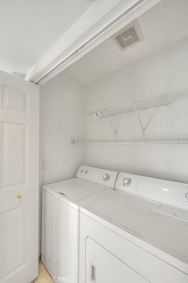 1995 Las Colinas Cir Unit 307, Corona, CA 92879 - laundry area with washer and dryer and a textured ceiling