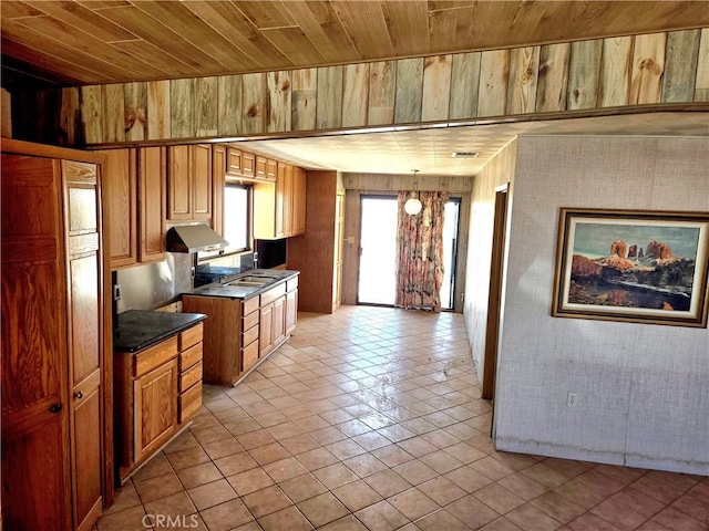 195 Old El Mirage Rd, Adelanto, CA 92301 - kitchen with dark countertops, wood ceiling, wooden walls, light tile patterned floors, and under cabinet range hood