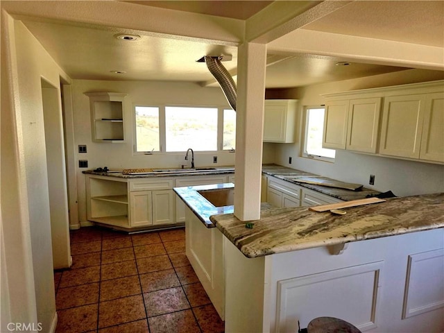 195 Old El Mirage Rd, Adelanto, CA 92301 - kitchen featuring open shelves, a sink, white cabinetry, and light stone counters