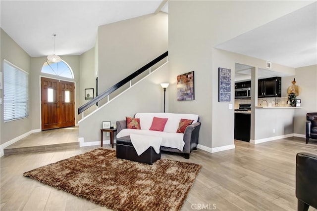 5840 Fairlane Dr, Riverside, CA 92506 - foyer entrance with stairway, light wood-style flooring, high vaulted ceiling, and baseboards