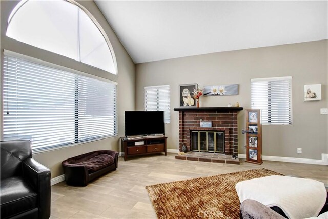 5840 Fairlane Dr, Riverside, CA 92506 - living area with plenty of natural light, a fireplace, vaulted ceiling, and baseboards