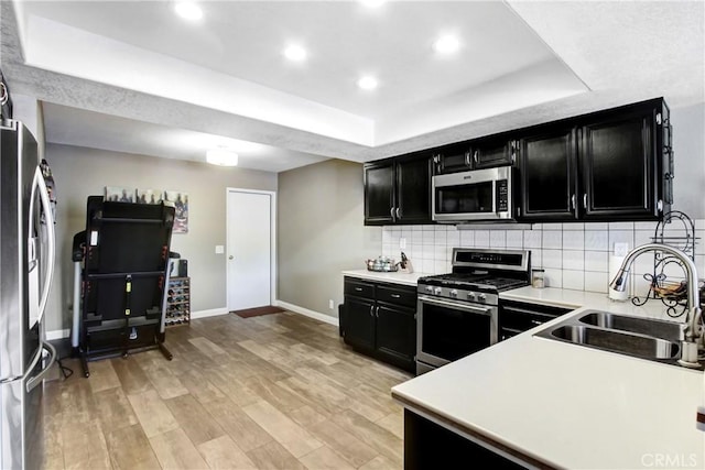 5840 Fairlane Dr, Riverside, CA 92506 - kitchen with stainless steel appliances, dark cabinets, a raised ceiling, a sink, and baseboards