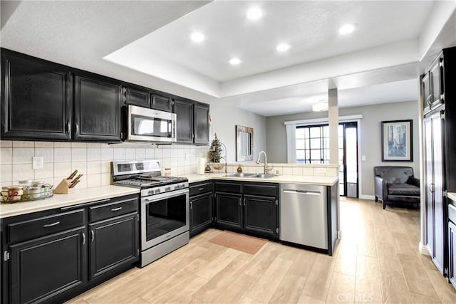5840 Fairlane Dr, Riverside, CA 92506 - kitchen with stainless steel appliances, dark cabinetry, a sink, a peninsula, and light countertops