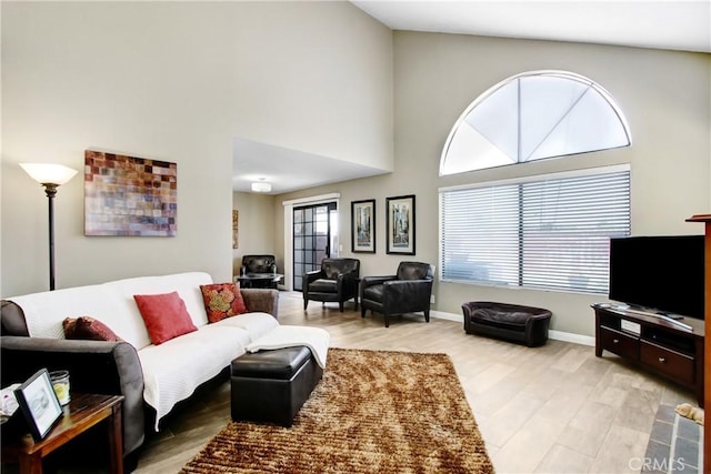 5840 Fairlane Dr, Riverside, CA 92506 - living room featuring light wood-type flooring, a towering ceiling, and baseboards