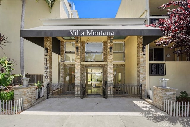 11970 Montana Ave Unit 102, Brentwood, CA 90049 - doorway to property featuring stucco siding and stone siding