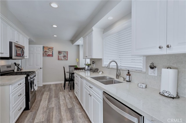 14522 San Feliciano Ln, Mirada, CA 90638 - kitchen with appliances with stainless steel finishes, a sink, recessed lighting, white cabinets, and light wood-style floors