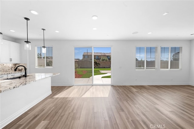 32129 Dymondia Way, Temecula, CA 92591 - unfurnished living room featuring a sink, light wood-type flooring, baseboards, and recessed lighting