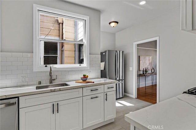 874 41st Ave, San Francisco, CA 94121 - kitchen featuring appliances with stainless steel finishes, a sink, white cabinetry, tasteful backsplash, and light stone counters