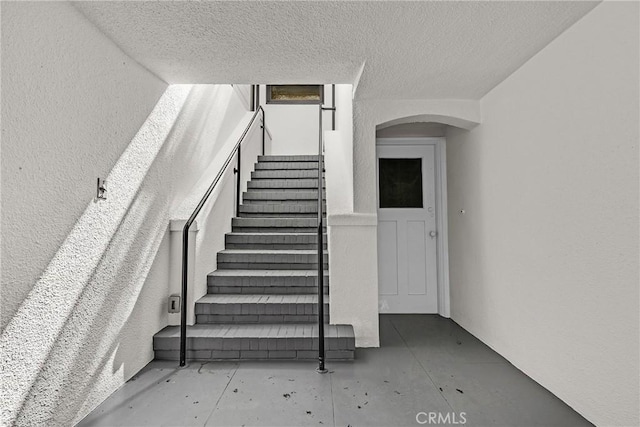 874 41st Ave, San Francisco, CA 94121 - staircase featuring arched walkways and a textured ceiling