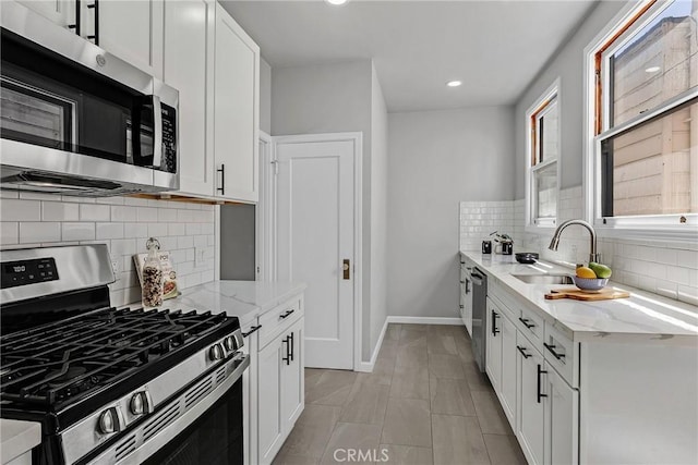 874 41st Ave, San Francisco, CA 94121 - kitchen featuring stainless steel appliances, a sink, light stone counters, white cabinetry, and recessed lighting