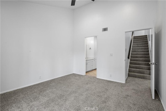 1188 Via Montoya, Camarillo, CA 93010 - empty room featuring light colored carpet, ceiling fan, stairs, a high ceiling, and baseboards