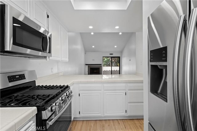 1188 Via Montoya, Camarillo, CA 93010 - kitchen featuring stainless steel appliances, tile counters, light wood-style flooring, white cabinets, and recessed lighting