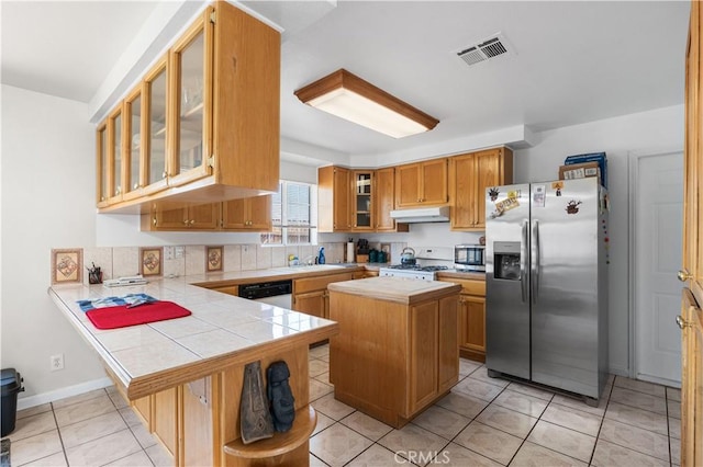 9824 Evelyn Ave, California City, CA 93505 - kitchen with stainless steel appliances, under cabinet range hood, a peninsula, a center island, and brown cabinetry