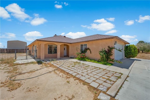 9824 Evelyn Ave, California City, CA 93505 - view of front of home with stucco siding, a garage, and concrete driveway