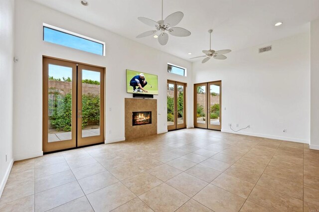 74158 Pele Pl, Palm Desert, CA 92211 - unfurnished living room featuring french doors, light tile patterned floors, a ceiling fan, recessed lighting, and a fireplace
