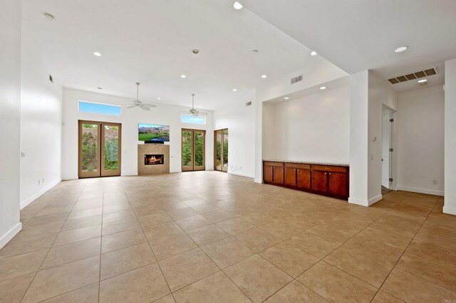 74158 Pele Pl, Palm Desert, CA 92211 - unfurnished living room featuring light tile patterned floors, a ceiling fan, a warm lit fireplace, baseboards, and recessed lighting