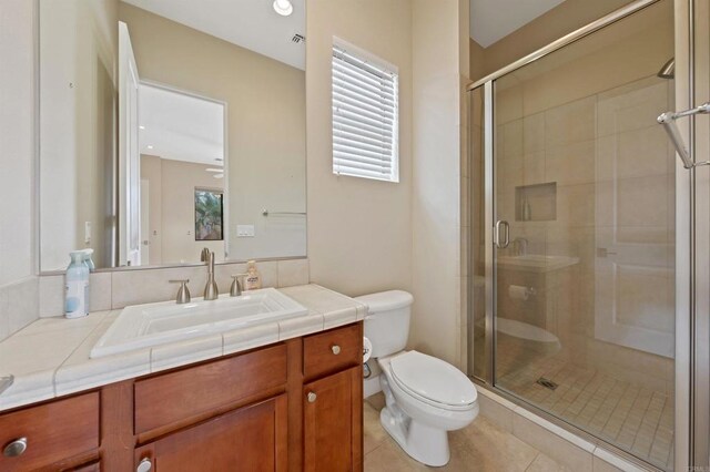 74158 Pele Pl, Palm Desert, CA 92211 - bathroom featuring toilet, vanity, a shower stall, and tile patterned floors