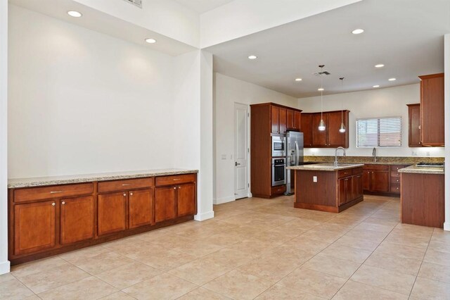 74158 Pele Pl, Palm Desert, CA 92211 - kitchen featuring appliances with stainless steel finishes, a center island with sink, a sink, recessed lighting, and light stone countertops
