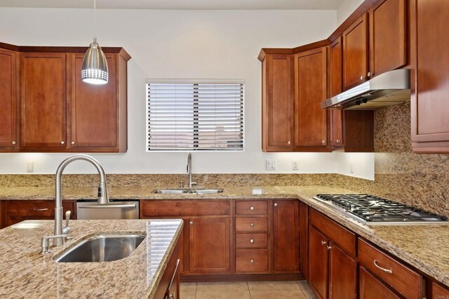 74158 Pele Pl, Palm Desert, CA 92211 - kitchen with under cabinet range hood, stainless steel gas cooktop, a sink, and light stone counters
