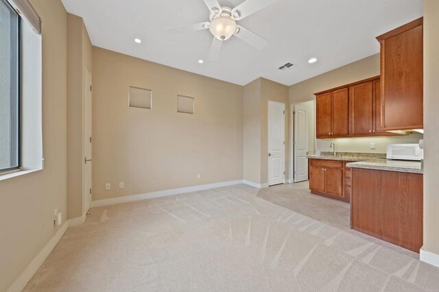 74158 Pele Pl, Palm Desert, CA 92211 - kitchen with light colored carpet, white microwave, brown cabinetry, and recessed lighting