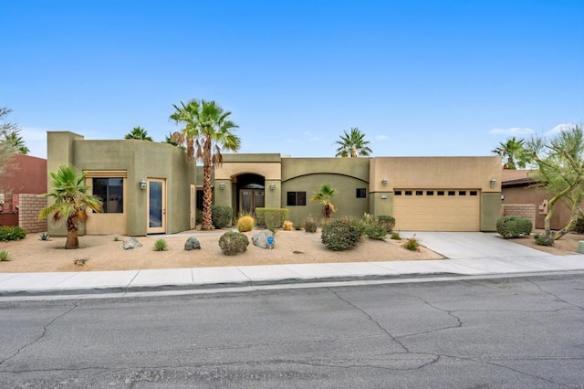 74158 Pele Pl, Palm Desert, CA 92211 - southwest-style home featuring an attached garage, concrete driveway, and stucco siding