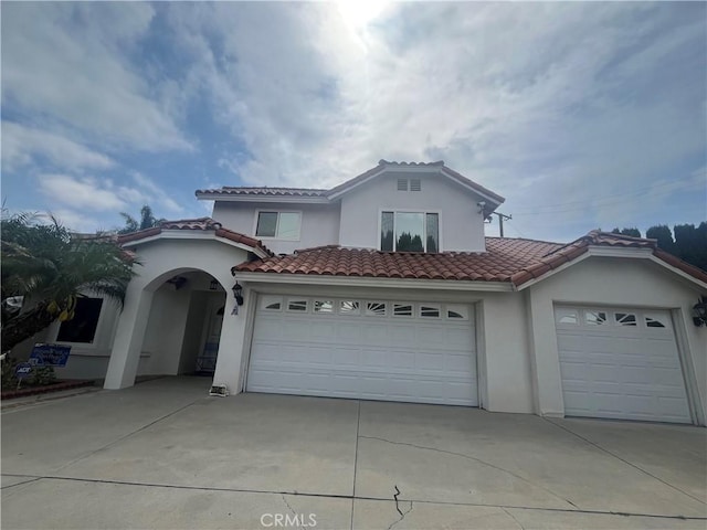 2445 N Santiago Blvd, Orange, CA 92867 - mediterranean / spanish-style house featuring driveway, stucco siding, a tiled roof, and a garage