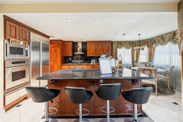 2445 N Santiago Blvd, Orange, CA 92867 - kitchen featuring built in appliances, wall chimney exhaust hood, an island with sink, a breakfast bar area, and recessed lighting