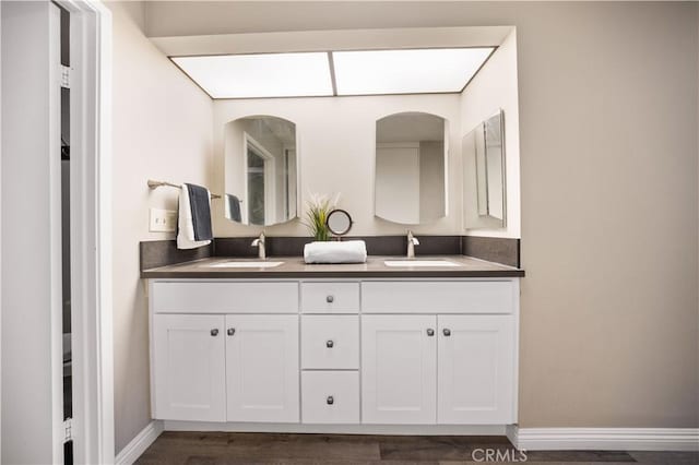 11 Palos Unit 55, Irvine, CA 92612 - bathroom featuring double vanity, baseboards, and wood finished floors