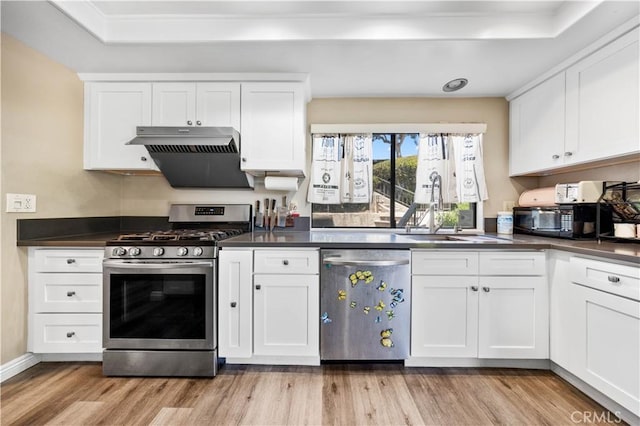 11 Palos Unit 55, Irvine, CA 92612 - kitchen with stainless steel appliances, dark countertops, light wood-type flooring, white cabinetry, and range hood