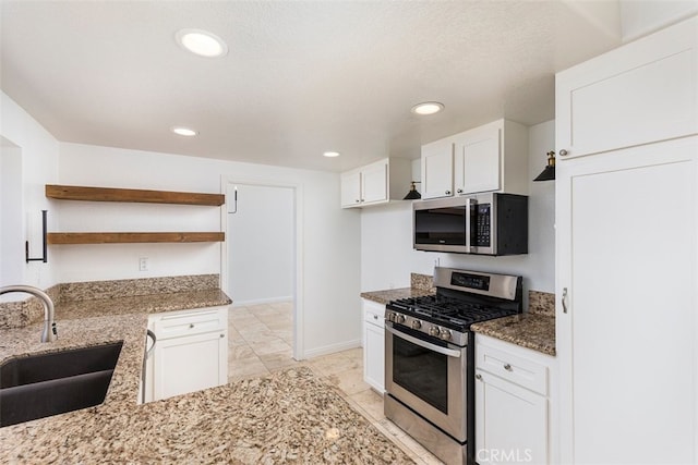 28705 Bridge Water Ln, Menifee, CA 92584 - kitchen featuring appliances with stainless steel finishes, open shelves, light stone counters, white cabinetry, and recessed lighting