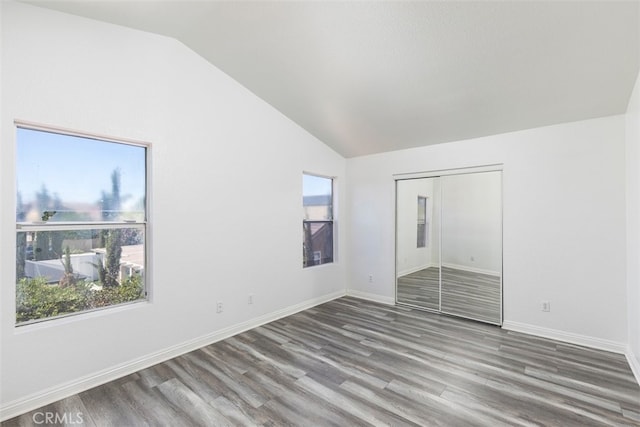 28705 Bridge Water Ln, Menifee, CA 92584 - unfurnished bedroom featuring vaulted ceiling, multiple windows, wood finished floors, and a closet