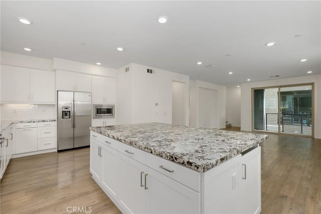 175 Cadence, Irvine, CA 92618 - kitchen with appliances with stainless steel finishes, a kitchen island, light stone countertops, recessed lighting, and backsplash