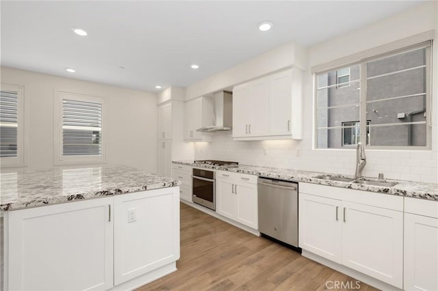 175 Cadence, Irvine, CA 92618 - kitchen with appliances with stainless steel finishes, wall chimney range hood, a sink, tasteful backsplash, and recessed lighting