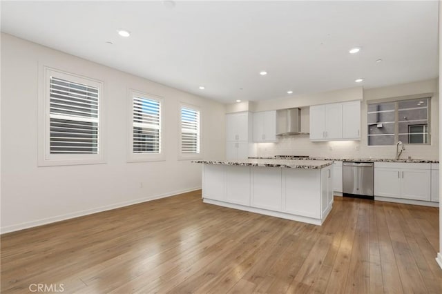 175 Cadence, Irvine, CA 92618 - kitchen featuring stainless steel dishwasher, wall chimney range hood, a sink, light wood-style flooring, and white cabinets