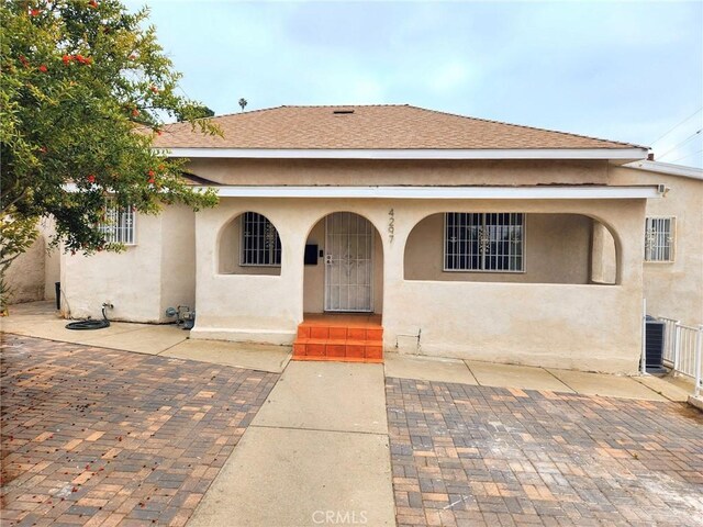 4297 Moonstone Dr, Los Angeles, CA 90032 - view of front facade featuring stucco siding, central AC, covered porch, and roof with shingles