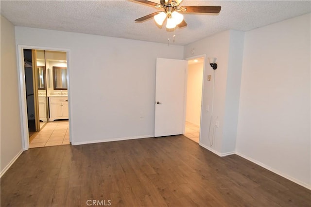 5369 Algarrobo Unit 1G, Laguna Woods, CA 92637 - unfurnished bedroom featuring wood finished floors, a textured ceiling, baseboards, and ceiling fan