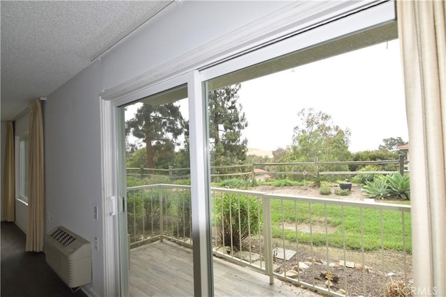 5369 Algarrobo Unit 1G, Laguna Woods, CA 92637 - doorway with a textured ceiling, wood finished floors, and a wall mounted air conditioner