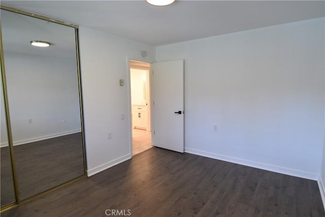 5369 Algarrobo Unit 1G, Laguna Woods, CA 92637 - unfurnished bedroom featuring dark wood-style flooring and a closet