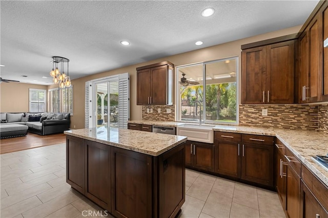 29012 Madrid Pl, Castaic, CA 91384 - kitchen featuring a kitchen island, tasteful backsplash, light stone countertops, a ceiling fan, and recessed lighting