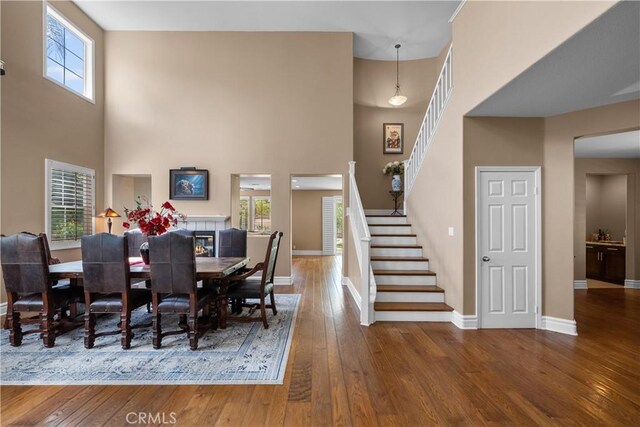 29012 Madrid Pl, Castaic, CA 91384 - dining room with a towering ceiling, stairway, hardwood / wood-style floors, and baseboards