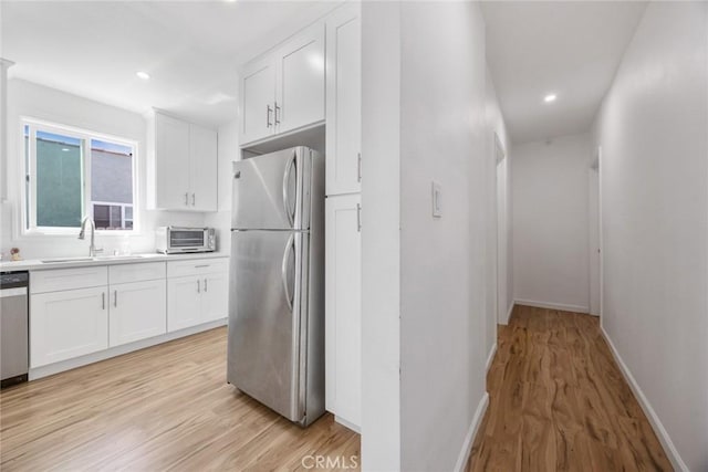 7037 Cimarron St, Los Angeles, CA 90047 - kitchen featuring stainless steel appliances, light wood finished floors, white cabinets, and recessed lighting