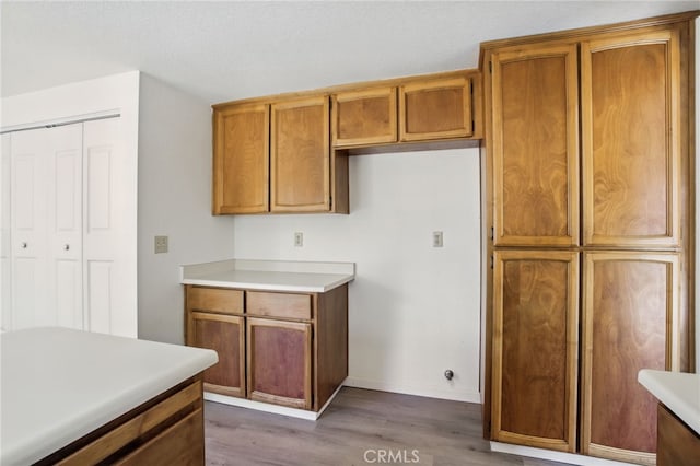 7000 Verdure Way, Elk Grove, CA 95758 - kitchen with wood finished floors, brown cabinets, baseboards, and light countertops