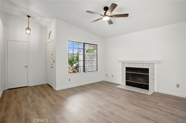 7000 Verdure Way, Elk Grove, CA 95758 - unfurnished living room with vaulted ceiling, wood finished floors, ceiling fan, a tiled fireplace, and baseboards