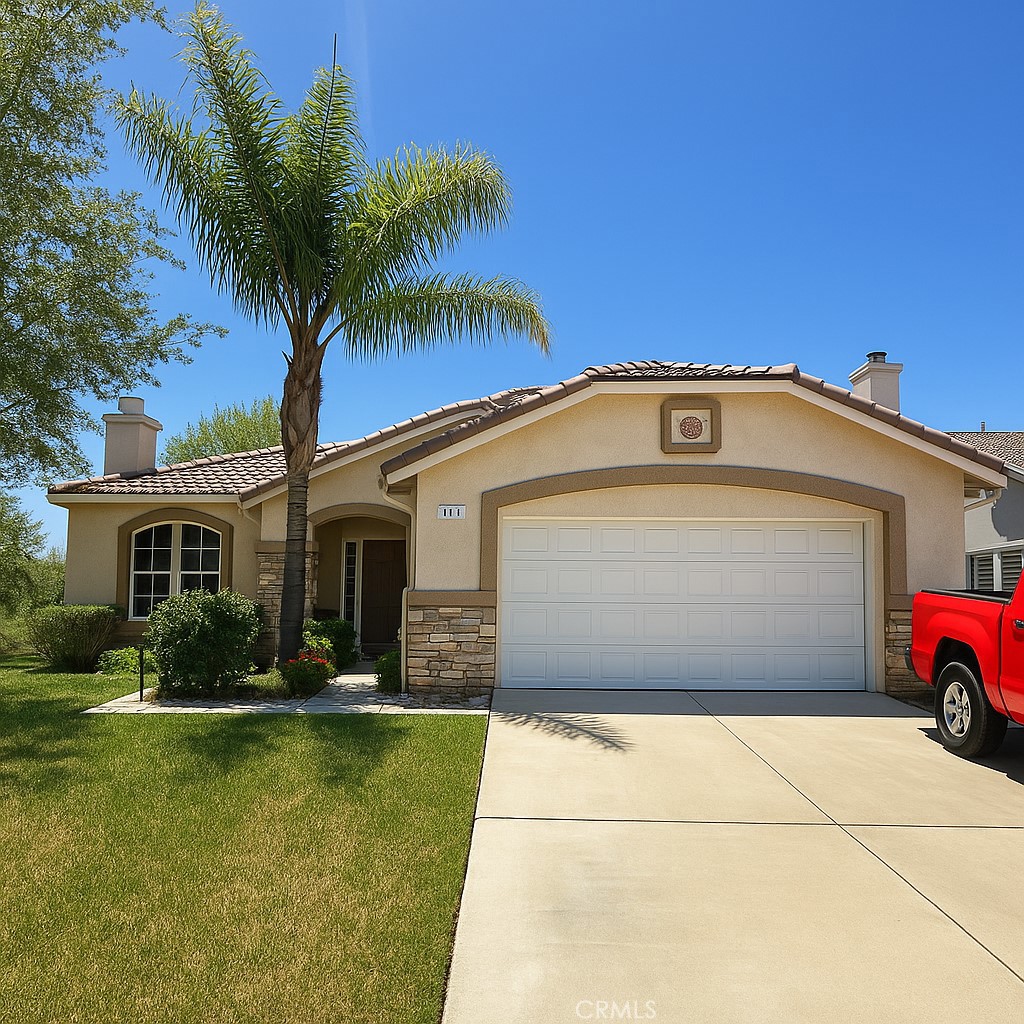 889 Sycamore Ct, Banning, CA 92220 - view of front of house with a chimney, stone siding, stucco siding, and concrete driveway