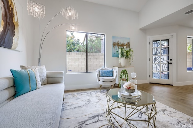 658 S Webster Ave Unit 4, Anaheim, CA 92804 - living area featuring plenty of natural light, wood finished floors, baseboards, vaulted ceiling, and a chandelier